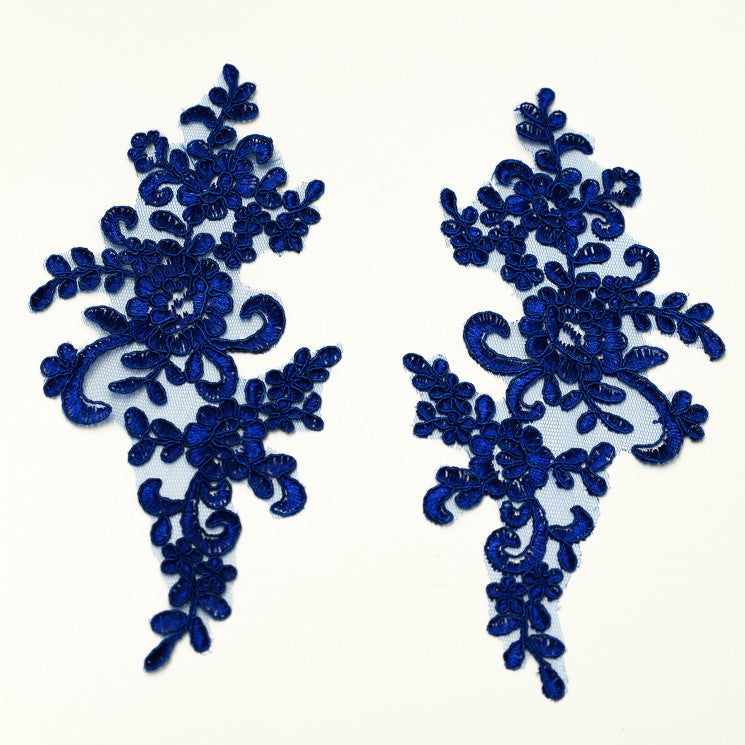 A royal blue embroidered and corded floral  applique pair laying flat on a white background.