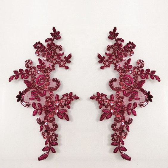 Burgundy sequin applique pair with floral design and edged with burgundy cord.  