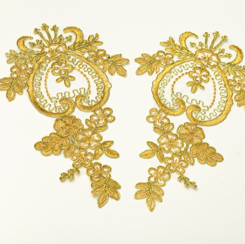 A bright gold embroidered medallion style applique pair with gold cording and and a floral trailing design at the bottom edge . 