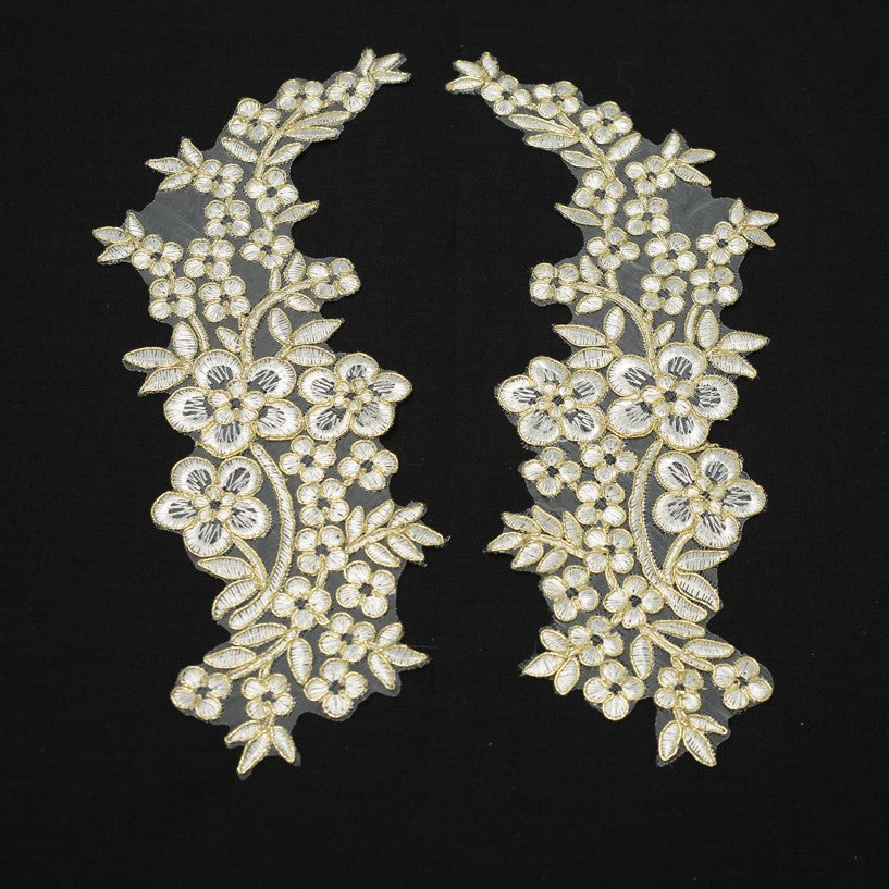 Mirrorred pair of white and gold costume appliques in a floral design.