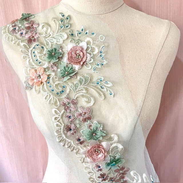 #D Floral border lace in pink and green  displayed across the bodice of a mannequin. 