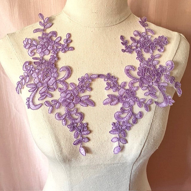 Purple mauve floral corded applique displayed on a mannequin .