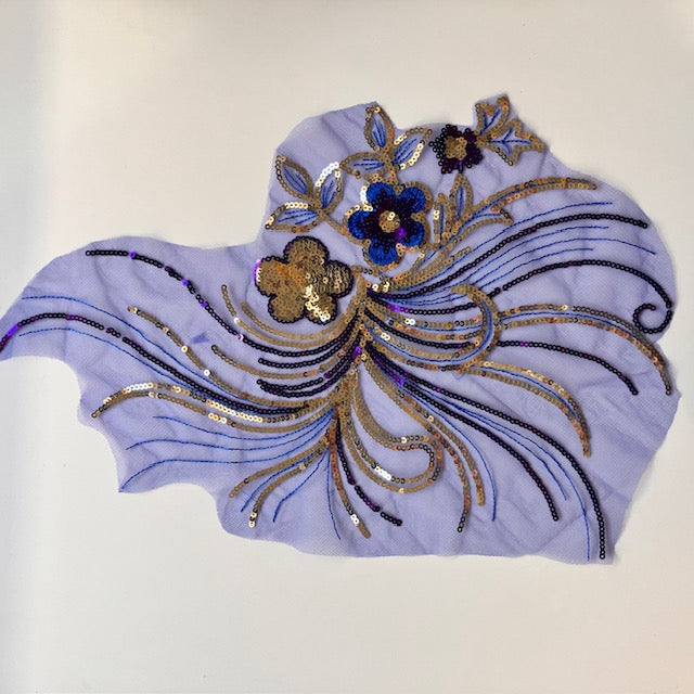 A royal blue and siver seqinned applique with 3 central sequinned flowers and swirling stems in silver and blue.
