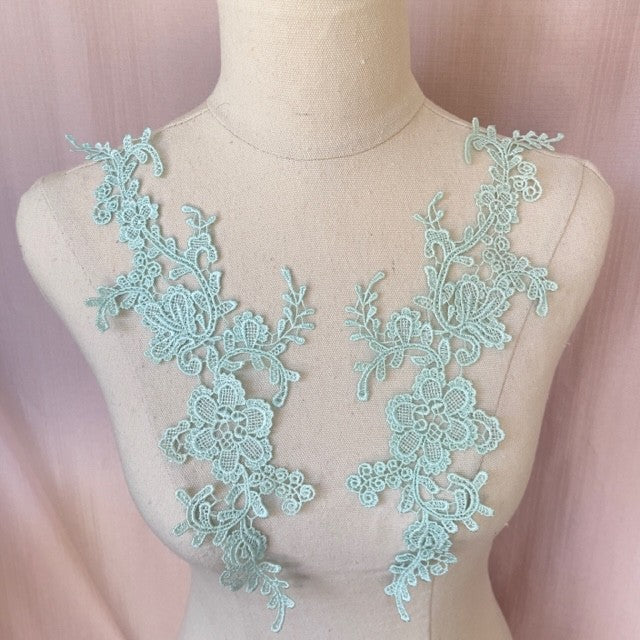 Heavily embroidered ice green floral applique pair.  The appliques are displayed on a mannequin.