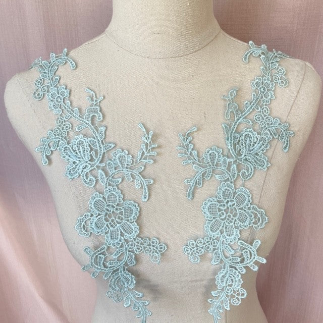 Heavily embroidered ice blue floral applique pair.  The appliques are displayed on a mannequin.