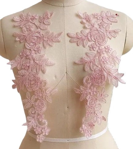 A generous sized pink corded applique embroidered onto an organza backing.  The appliques are displayed on a mannequin.