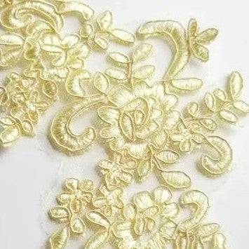 Close up of the flowers and leaf design of the corded yellow applique .