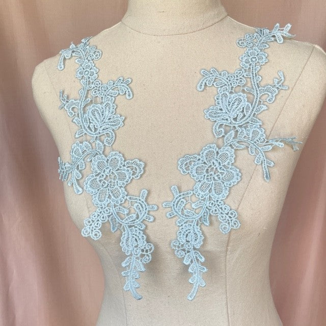 Heavily embroidered pale blue floral applique pair.  The appliques are displayed on a mannequin.