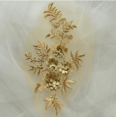 Soft gold coloured applique with 3D flowers shown against a net background 