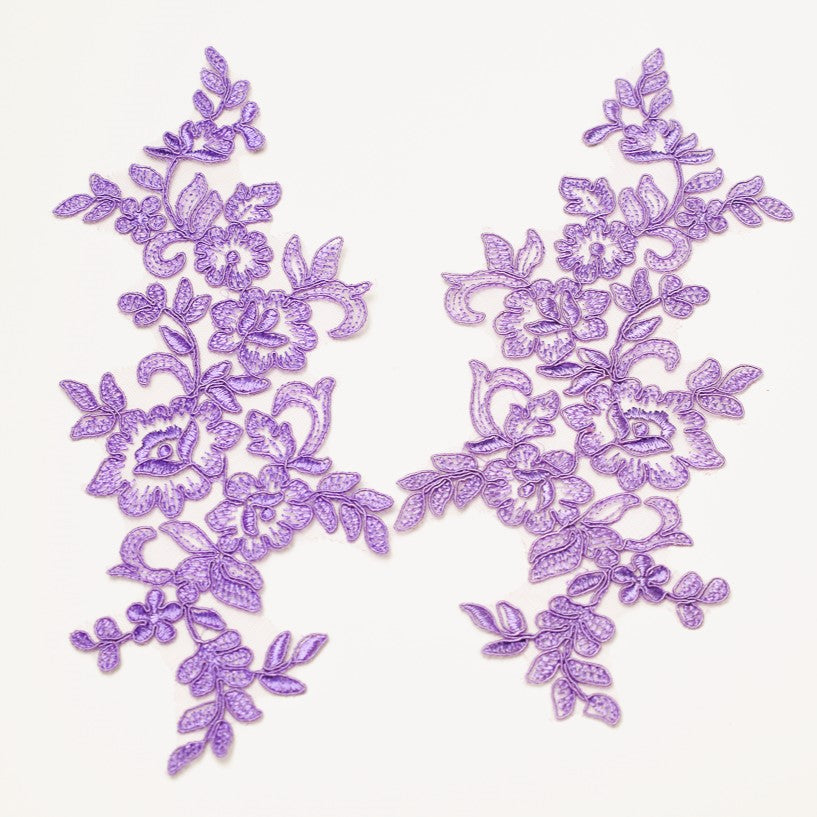 A mirrorred pair of purple mauve corded appliques on a white background.