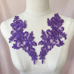 Heavily embroidered and corded purple mirrored lace applique pair.  The appliques are displayed on a model.