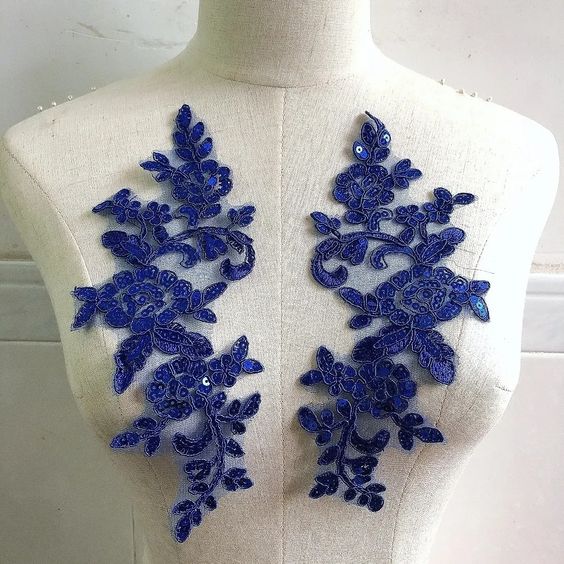 A mirrored pair of royal blue sequinned corded appliques displayed on a mannequin