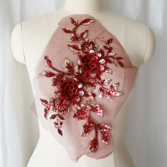 Large burgundy 3D floral sequinned applique. The burgundy sequinned leaves are highlighted with silver sequins . Shown displayed on a mannequin.