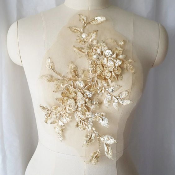A large pale gold and cream sequinned 3D floral applique displayed on a  mannequin .