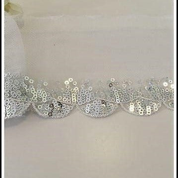 Tiny silver  sequins completely fill the double scallop pattern along the length of this sparkly trim