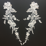 A beautiful pair of delicate ivory lace floral appliques.  These appliques are perfect for creating a trailing effect on a bridal gown skirt or tulle skirt.  They are scattered with clear sequins which shimmer under lights.