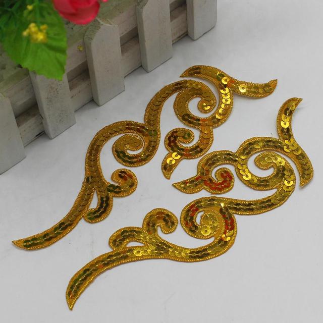 Mirrored pair of gold sequin appliques with scroll design laying flat on a white background.