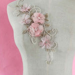 Gold embroidered single floral applique decorated with pink 3D organza flowers displayed on a mannequin.