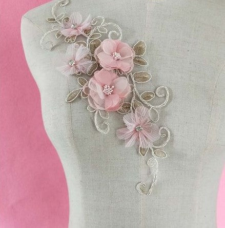 Gold embroidered single floral applique decorated with pink 3D organza flowers displayed on a mannequin.