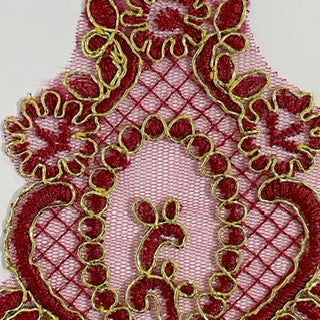 Burgundy embroidered applique edged with gold metallic thread.
