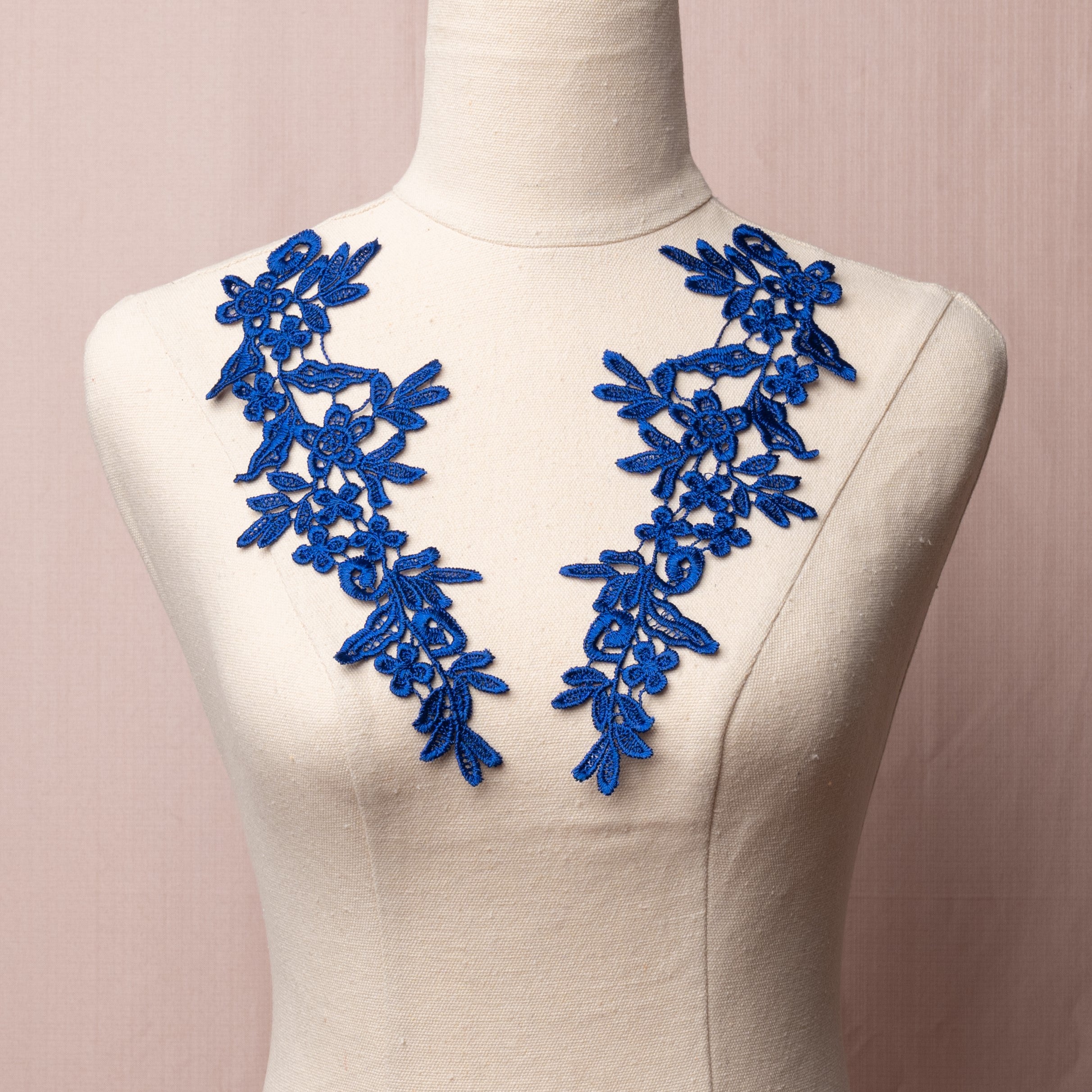 Heavily embroidered royal blue mirrored lace applique pair displayed on a mannequin.
