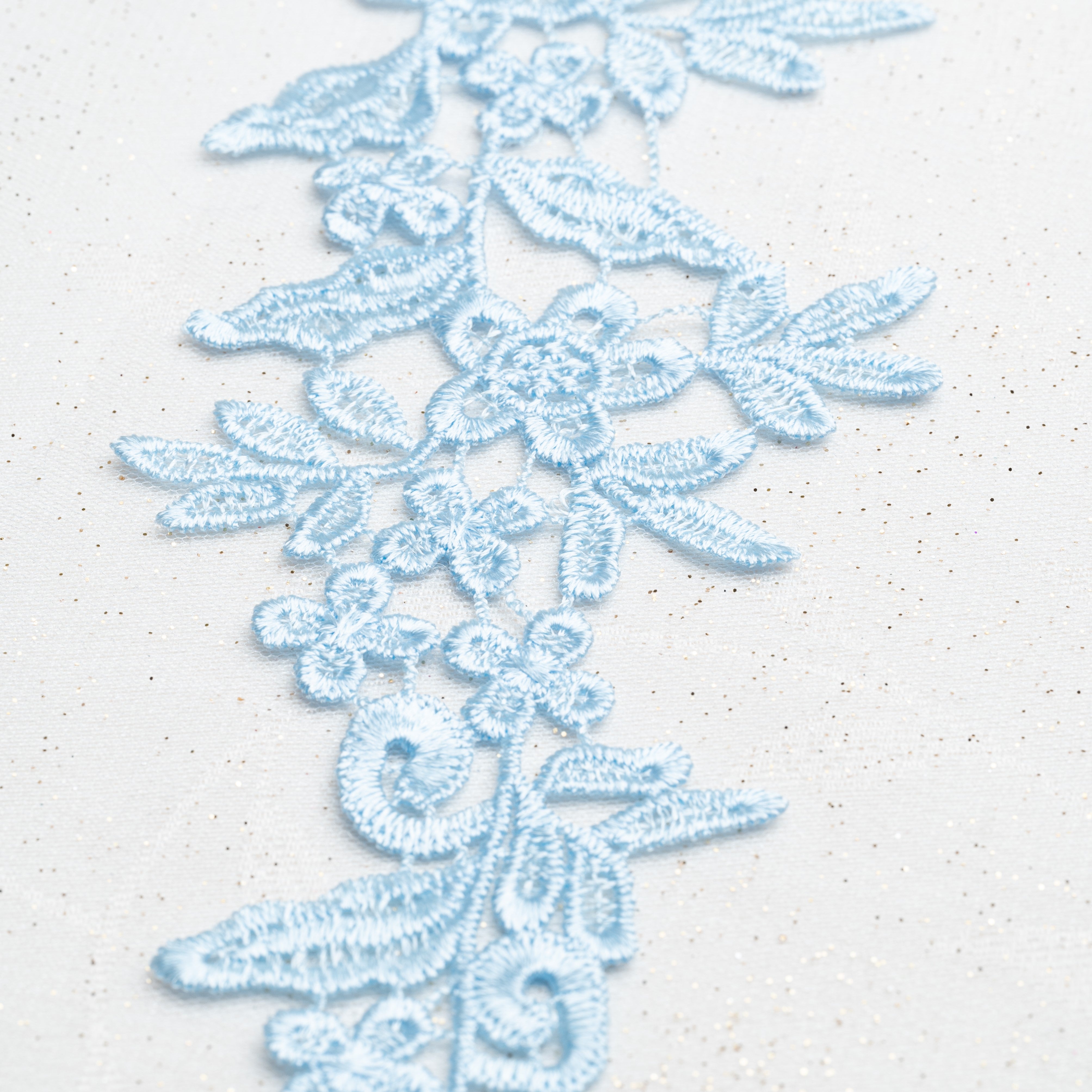 Heavily embroidered pale baby blue mirrored lace applique pair. The floral design is a perfect background for decorating with crystals, pearls, sequins and beads and can be cut up and rearranged into smaller motifs to decorate dance costumes.