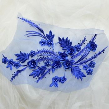 An embroidered  floral spray of satin and metallic threads. The blue costume applique features multi layered embroidered flowers with blue pearl centres and metallic embroidered fern fronds.  The blue floral appliques come as a mirrored pair making them suitable for costume and tutu bodices and tutu plates. 