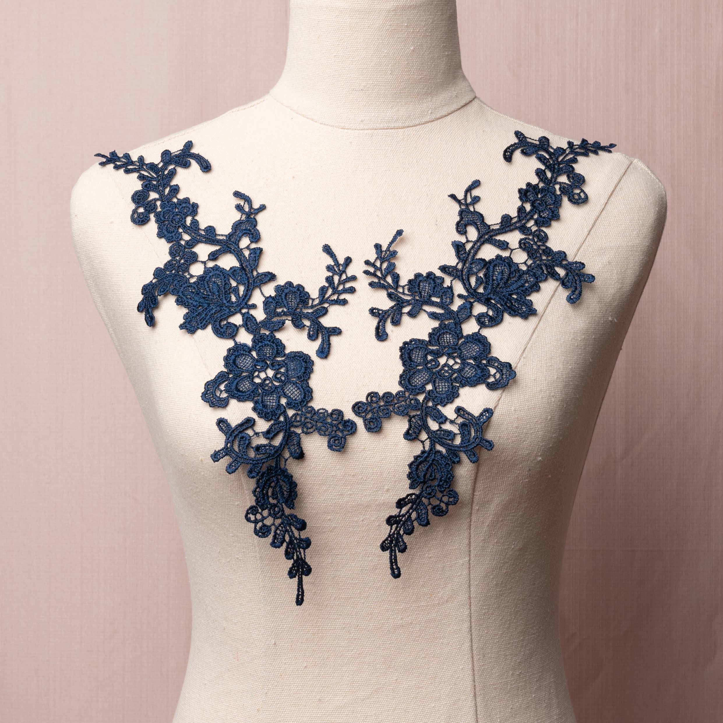 Heavily embroidered navy blue floral applique pair displayed on a mannequin.
