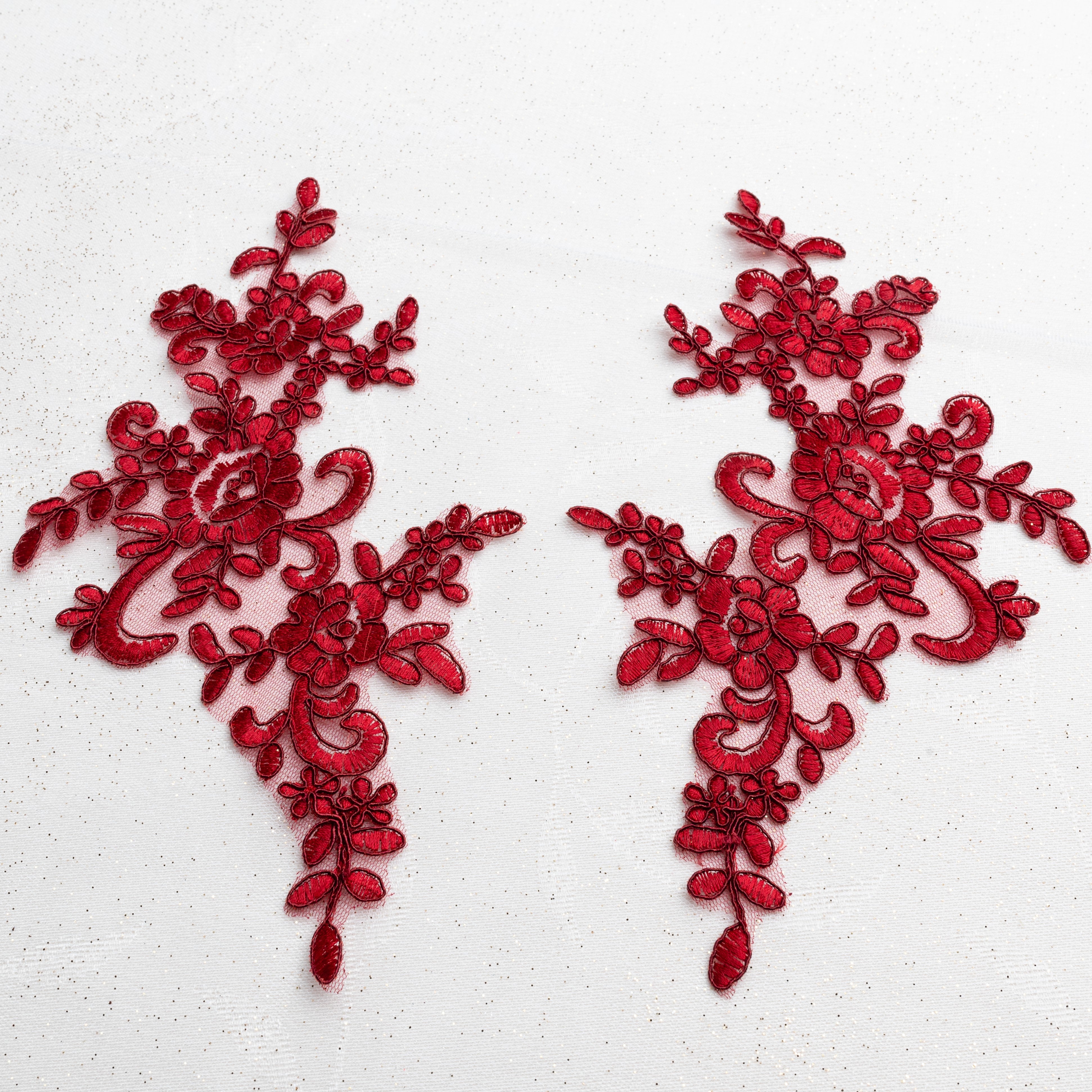 Mirrored pair of burgundy red corded appliques with a floral design and embroidered onto a fine net backing.