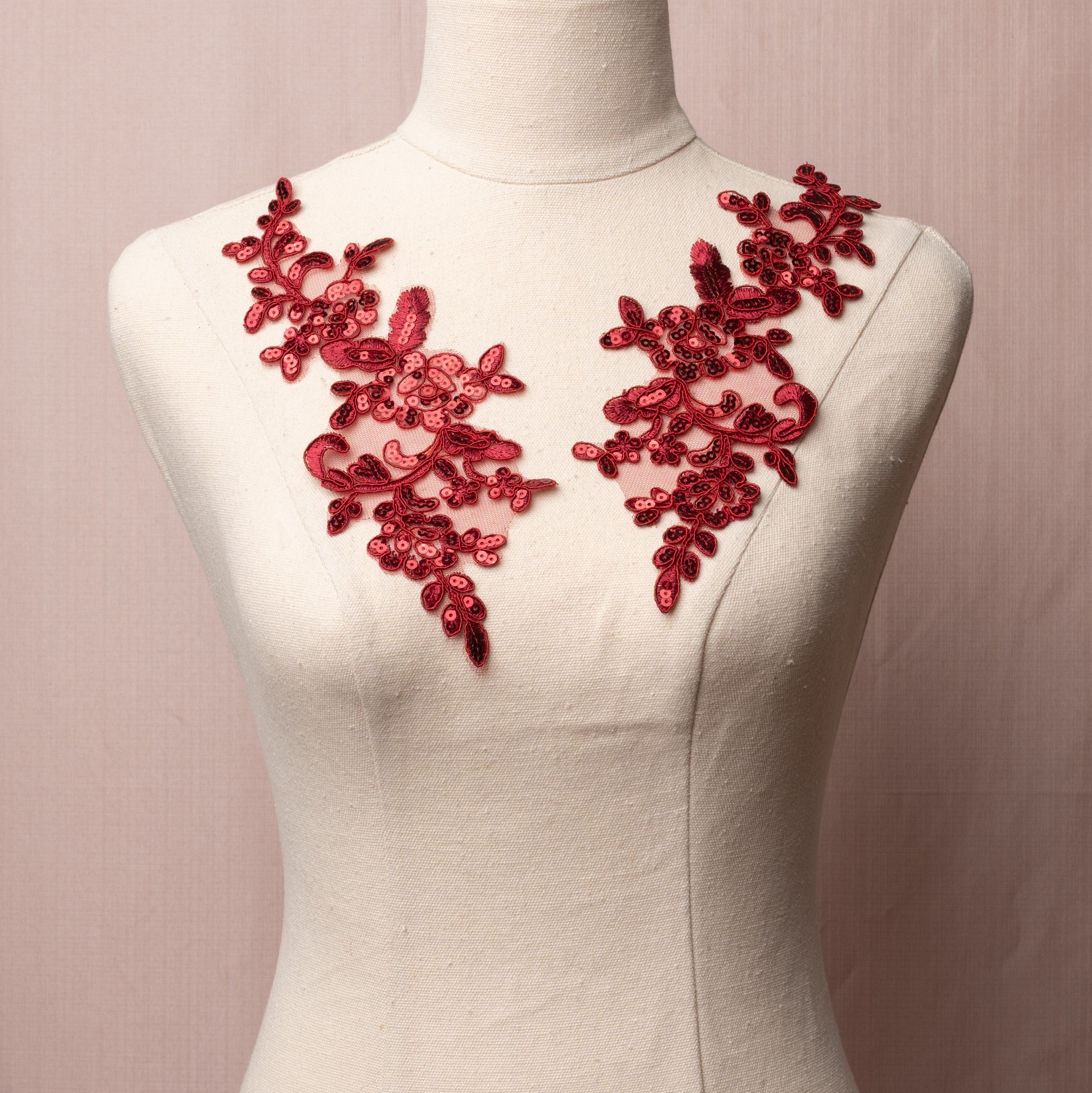 Burgundy sequinned floral applique pair displayed on a mannequin.