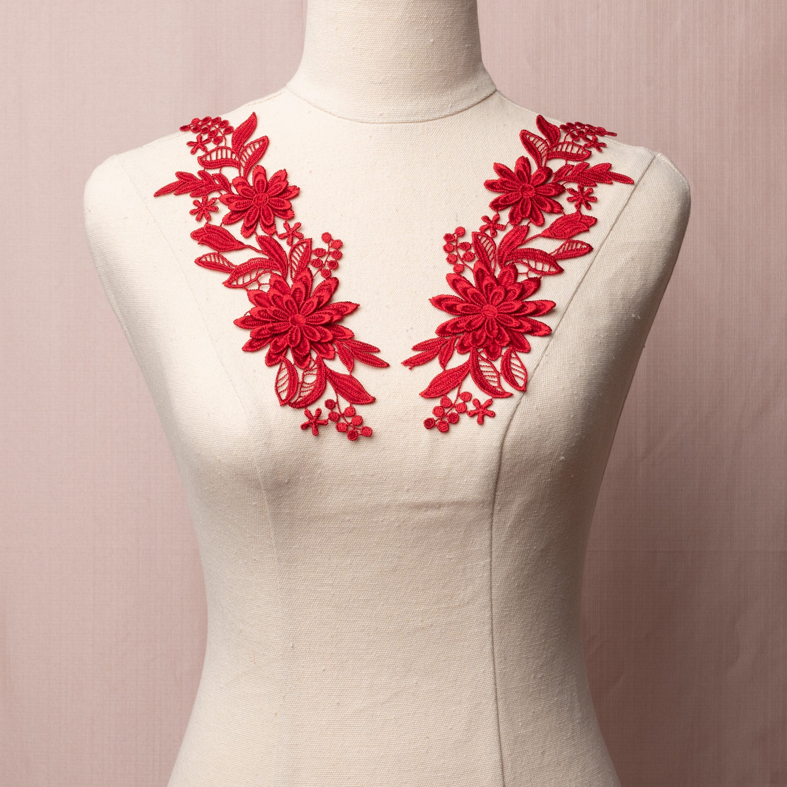 Embroidered burgundy 3D lace applique pair displayed on a mannequin