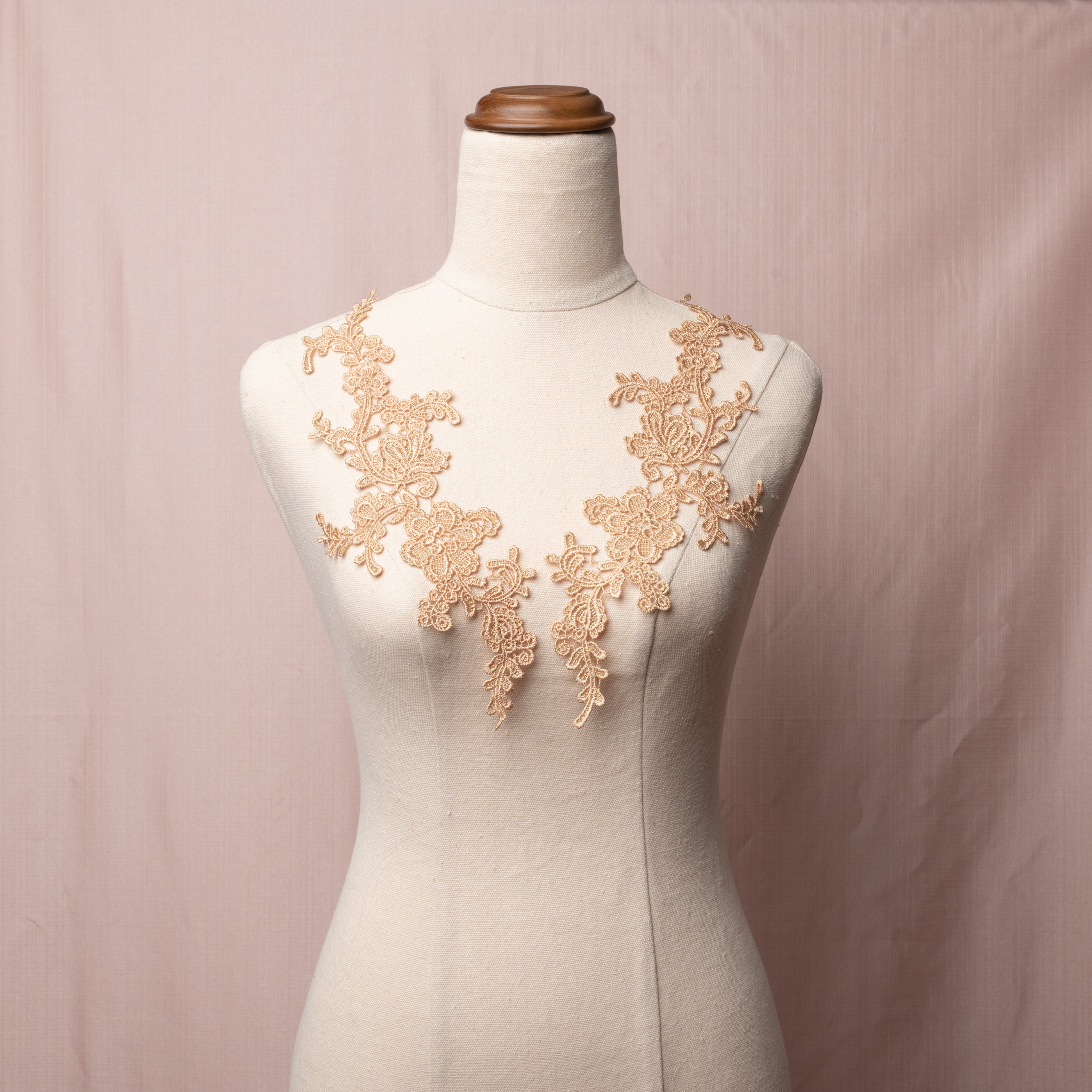 Heavily embroidered non metallic pale old gold floral applique pair.  The appliques are displayed on a dressmakers model.