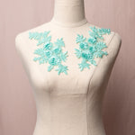 Embroidered ice green floral applique pair with 3D flowers displayed on a mannequin.