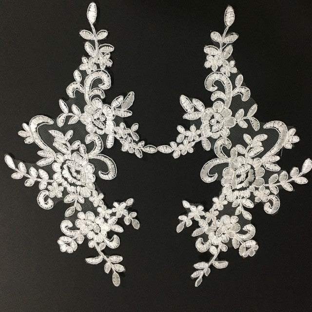 Embroidered ivory corded applique pair in a floral design.