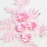 Close up view of pale pink embroidered floral applique with 3D flowers.