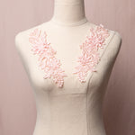 A pink dance costume applique with embroidered 3D flowers leaves and sprays of pompom buds. The appliques are displayed on a mannequin.