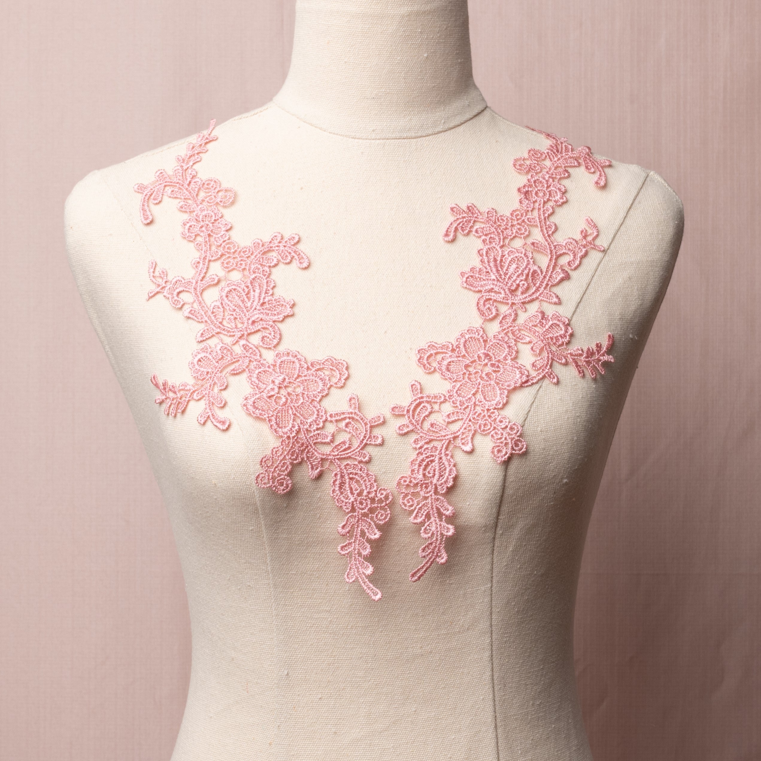 Heavily embroidered dusty pink lace floral applique pair displayed on a mannequin.