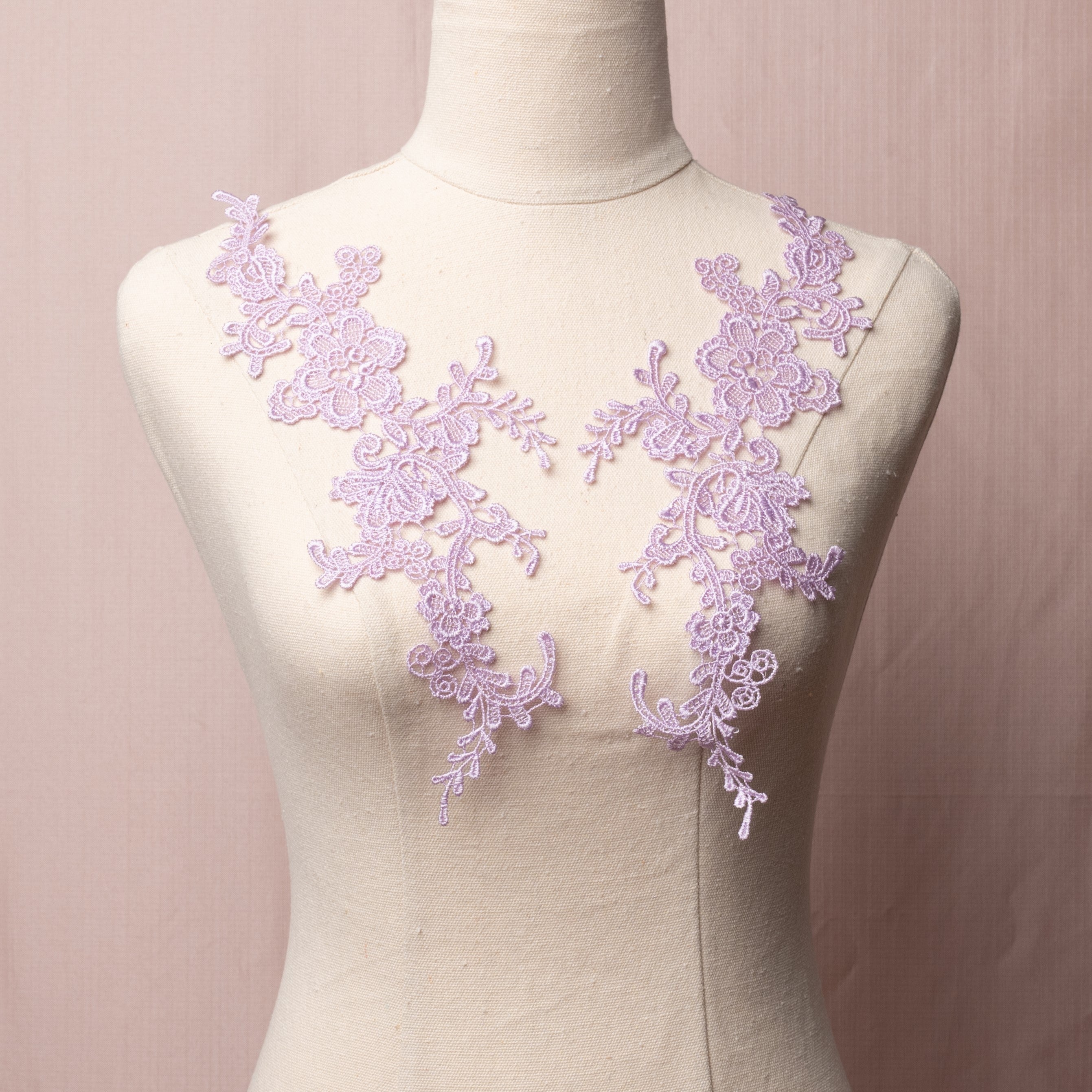 Heavily embroidered lilac floral applique pair displayed on a mannequin.