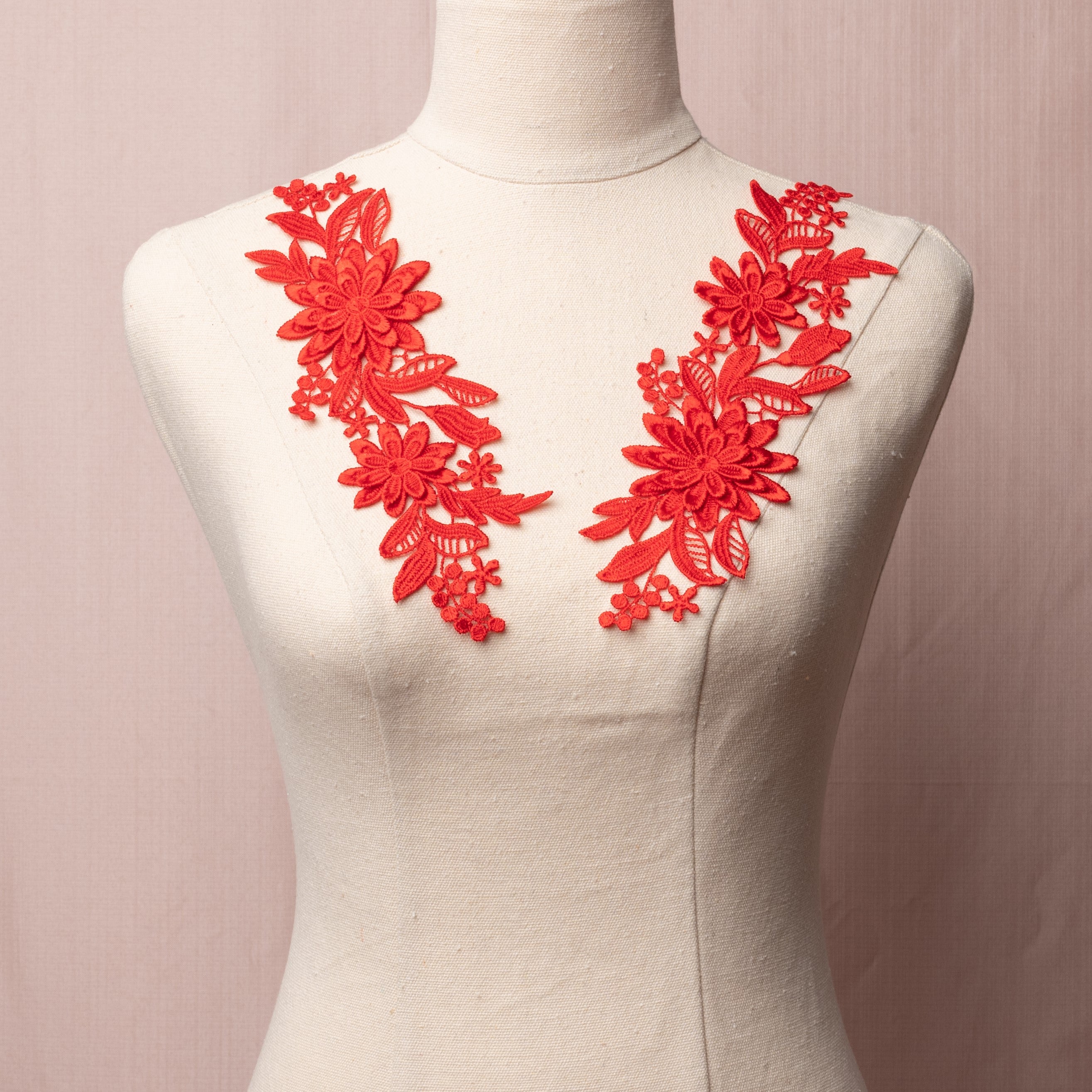 Embroidered red blue 3D lace applique pair displayed on a mannequin.