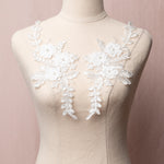 White 3D embroidered and corded appliques in a floral spray design.  The appliques are decorated with 3D floral flowers which have a white pearl centre.  The appliques are displayed on a mannequin.