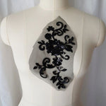 Black fully sequined floral applique  embroidered onto fine black net and displayed on a mannequin. 