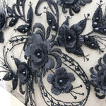 Close up of black 3D floral applique piece.  The flower centres and leaves are embellished with a black pearl.