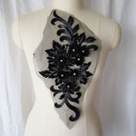 Single Black and  silver  floral applique. Metallic  silver thread outlines the petals and sequinned leaves .