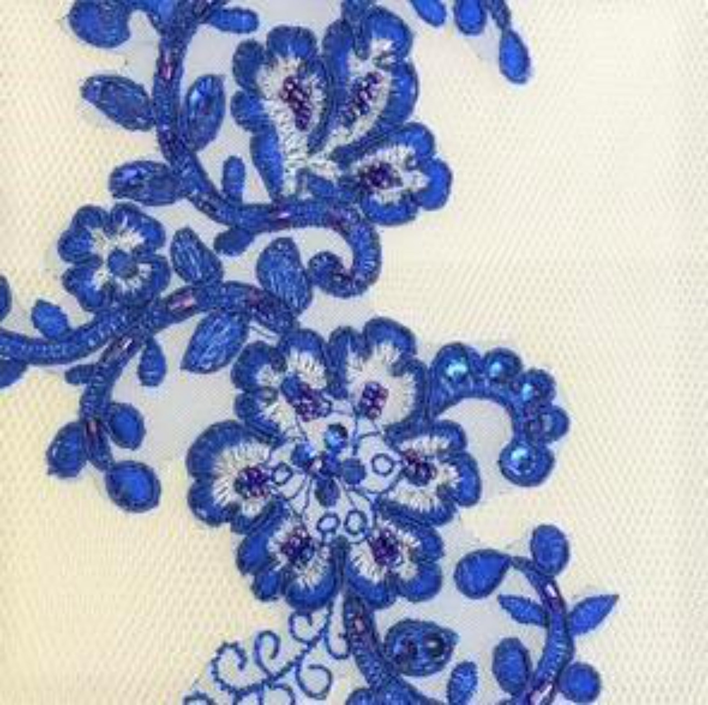 Gorgeous royal blue lace applique embroidered onto a fine net backing and embellished with beads. The flower motifs are embroidered with white thread and edged with royal blue thread around each petal. The petals are further embellished with seed beads in varying shades of blue and purple. Blue sequins edge the leaf shapes.