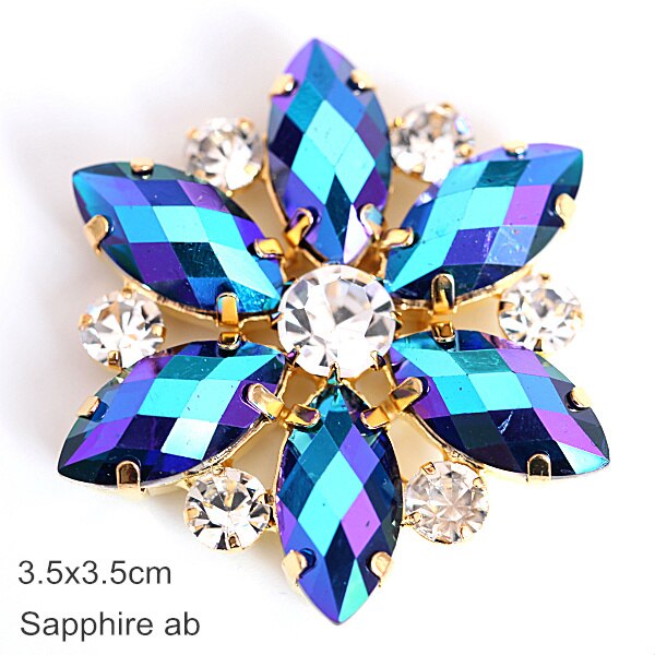 Flower shaped applique with tear drop shaped sapphire blue petals and a crystal rhinestone centre.  There is a crystal rhinestone in between each petal. 