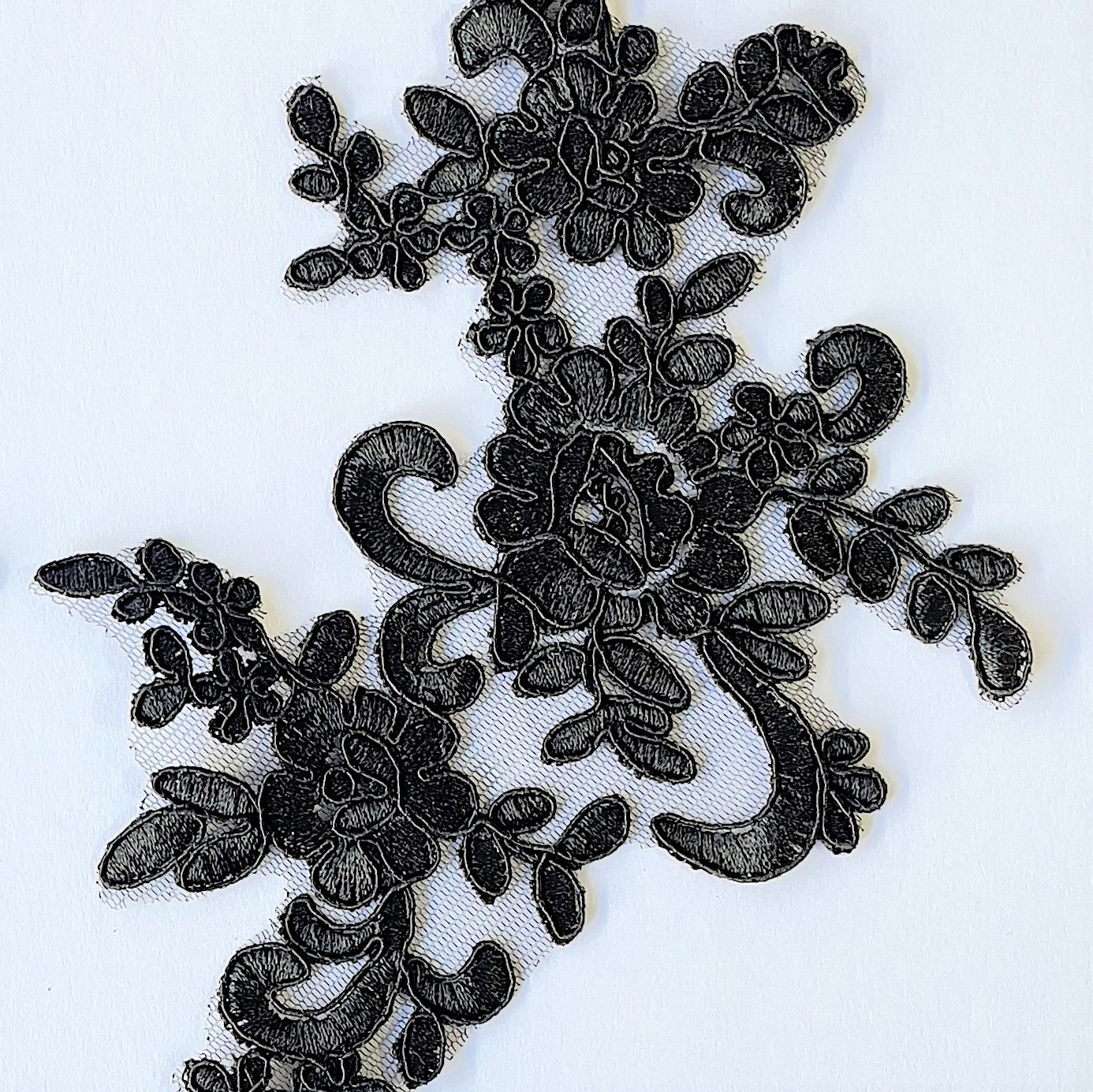 A closeup of the floral design of  the black corded lace applique .