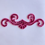Single fuchsia sequin scroll bodice applique filed with fuchsia sequins and edged with seed beads laying flat on a white background..