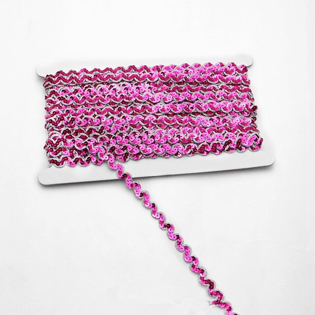 Fuchsia non-stretch sequins in a serpentine pattern edged with a metallic gold thread border.  The sequins are wrapped around a white card with a single strand lying flat across the image.