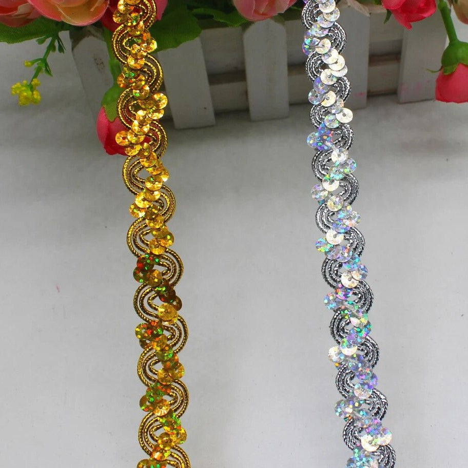 This photo shows a strand of gold sequinned trim in a wave design and a stand of silver sequinned trim in a wave design.