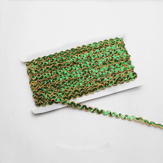 Green non-stretch sequins in a serpentine pattern edged with a metallic gold thread border.  The sequins are wrapped around a white card with a single strand lying flat across the image.